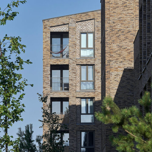 Kunststof kozijnen en Houten kozijnen voor 201 sociale huurwoningen in Ede. Foto van hoekbalkons van het project Op Enka.