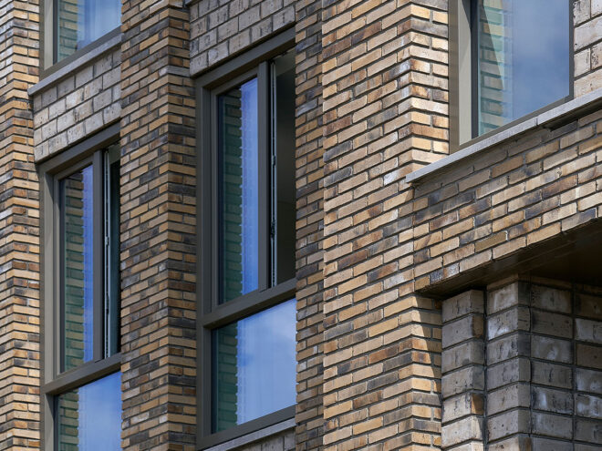 Kunststof kozijnen en Houten kozijnen voor 201 sociale huurwoningen in Ede. Foto van geopende ramen van het project Op Enka.