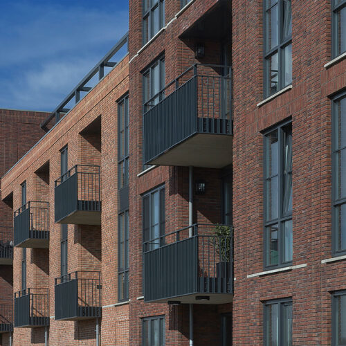 Houten kozijnen voor 47 woningen en 28 appartementen in Gouda, in de wijk Het Carré van Westergouwe. Foto van diverse balkons.