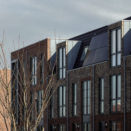 Houten kozijnen voor 47 woningen en 28 appartementen in Gouda, in de wijk Het Carré van Westergouwe. Foto van de gevel van een blok.