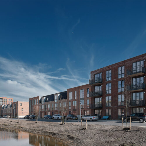Houten kozijnen voor 47 woningen en 28 appartementen in Gouda, in de wijk Het Carré van Westergouwe. Foto van de zijkant van een aantal blokken.