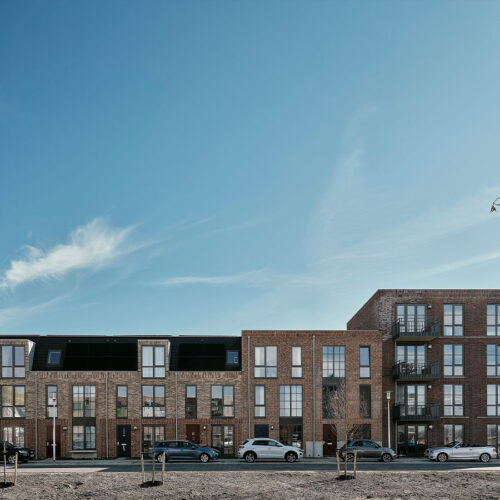 Houten kozijnen voor 47 woningen en 28 appartementen in Gouda, in de wijk Het Carré van Westergouwe. Foto van de voorzijde van een blok.